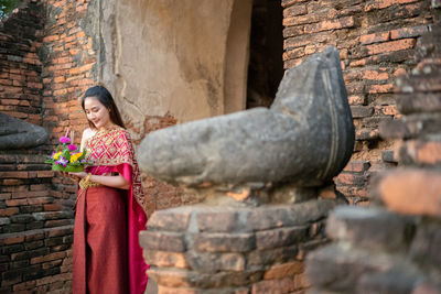 Woman standing against old temple