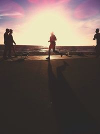 Woman standing on beach at sunset