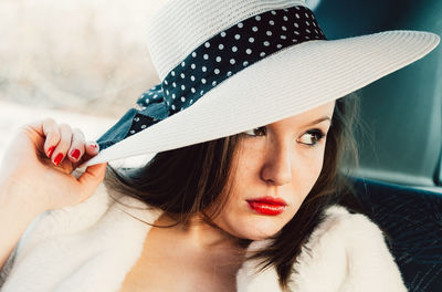 Close-up portrait of woman wearing hat