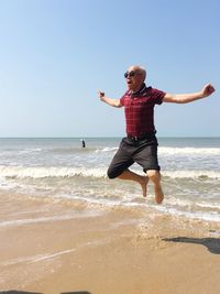 Full length of boy on beach against sky