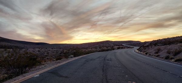 Empty road against sky during sunset