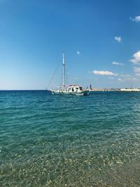 Sailboats in sea against blue sky