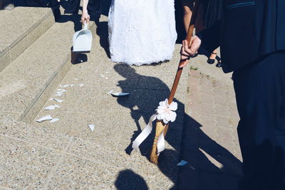 Low section of man sweeping the floor