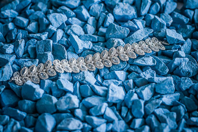 High angle view of diamond necklace on stones