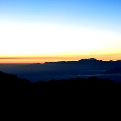 Scenic view of silhouette mountains against sky during sunset