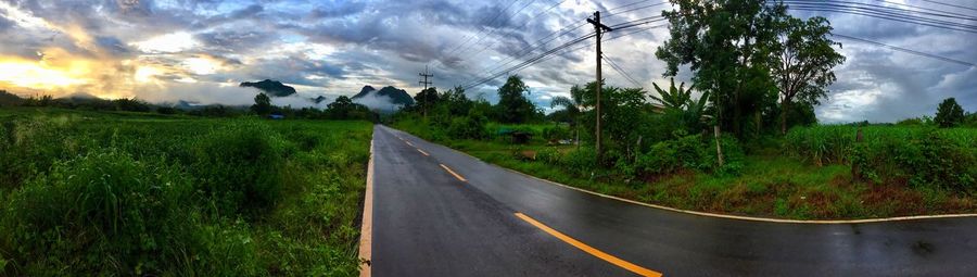 Road amidst green landscape against sky