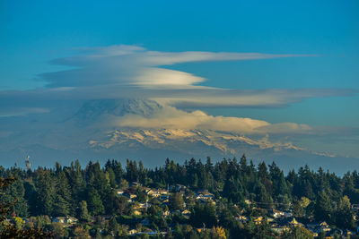 Saucer-shaped clouds hover over mount rainier in washington state.