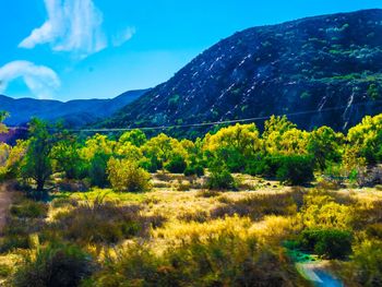 Scenic view of mountains against blue sky