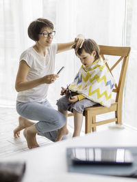 Mother cuts her sons hair. new normal, coronavirus covid-19 quarantine.