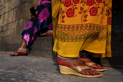 Low section of woman standing on footpath