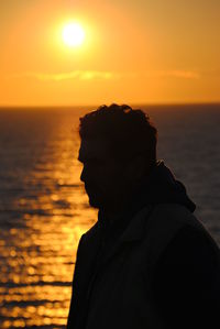 Silhouette man against sea during sunset