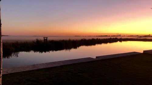 Scenic view of lake against sky during sunset