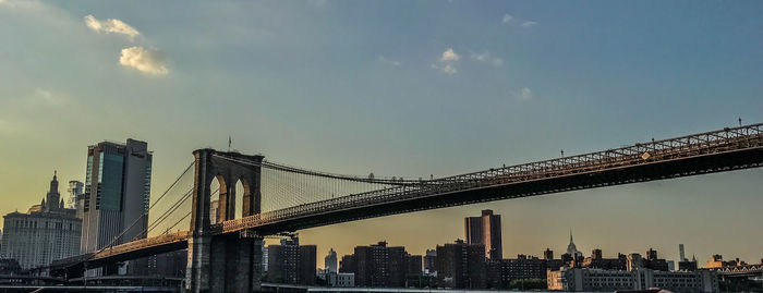 Low angle view of bridge and buildings against sky