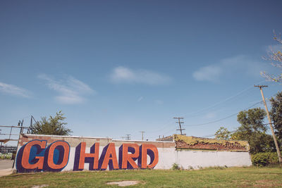 Information sign on field against sky