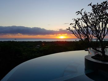 Scenic view of swimming pool against sky at sunset