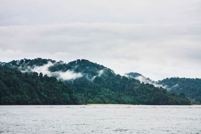 Scenic view of land and mountains against sky