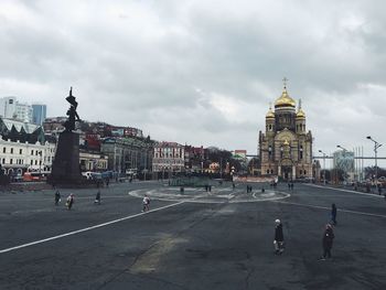 People walking on road against buildings