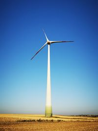 Low angle view of windmill on field against clear sky