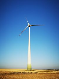 Low angle view of windmill on field against clear sky