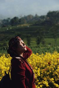 Mid adult woman with closed eyes standing on field