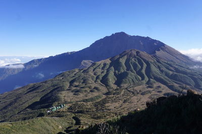 Scenic view of mountains against blue sky