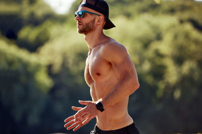 Portrait of shirtless man standing outdoors