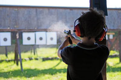 Young boy concentrates while shooting from a revolver at a shooting range