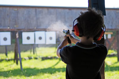 Rear view of boy photographing