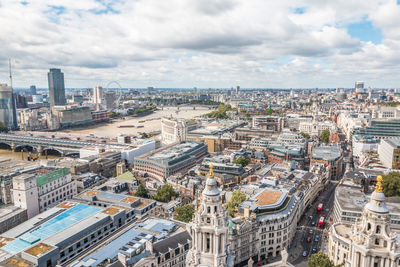 High angle view of city buildings against cloudy sky