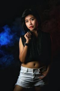 Portrait of female model posing against black background