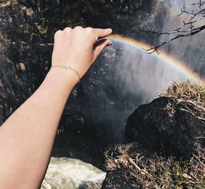 Midsection of person holding rock in water