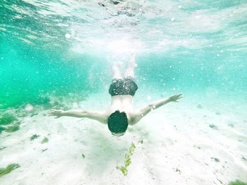 Carefree shirtless man swimming undersea