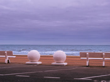 Chairs on beach against sky