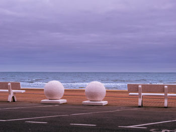 Beach promenade with marble benches and bowls
