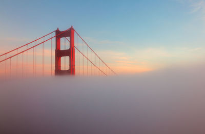 Low angle view of suspension bridge against sky during sunset