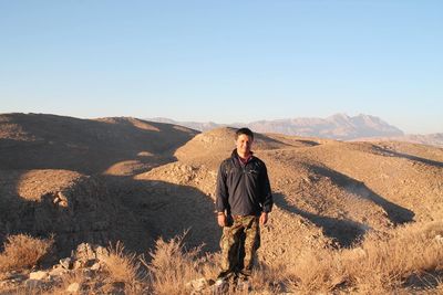 Man standing on mountain against clear sky