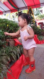 Cute girl looking down while standing outdoors