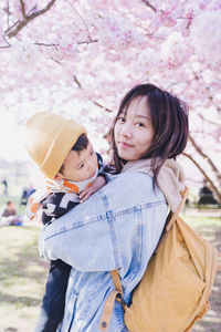 A mom held her son in her arms. it was sakura blossom time in spring in munich. 