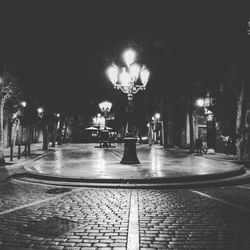 Illuminated street lights in city at night