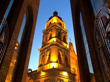 Low angle view of illuminated buildings against sky at night