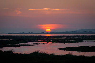 Scenic view of sea against romantic sky at sunset