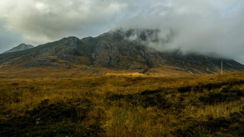 Scenic view of mountains against cloudy sky