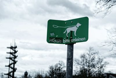 Close-up of road sign against sky