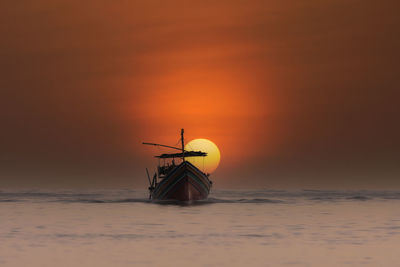 Silhouette ship in sea against sky during sunset