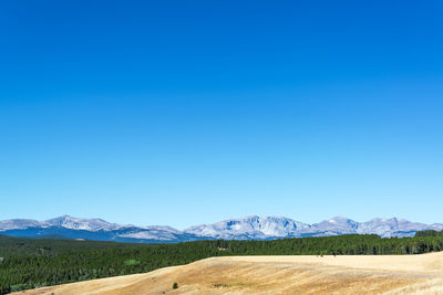 Scenic view of landscape and mountains against clear blue sky at bighorn mountains