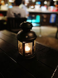 Close-up of illuminated lamp on table in restaurant