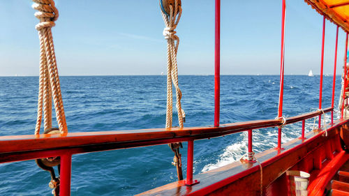 Boat sailing in sea against sky on sunny day