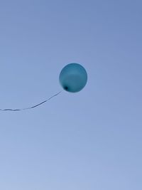 Low angle view of balloons against blue sky