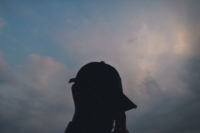 Low angle view of silhouette woman standing against sky during sunset