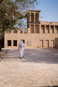 Rear view of man on cross against building